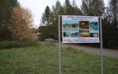 У разрушенного здания плавательного бассейна установлены информационные щиты